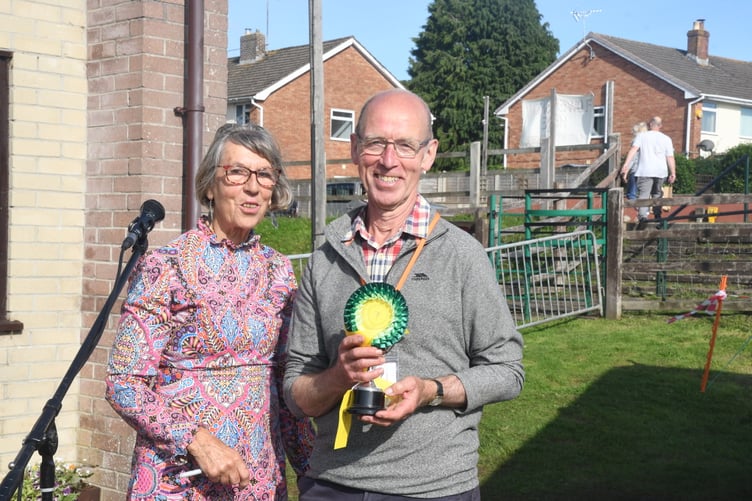 Show president Diana Standing presents the Butters Cup for a specimen rose to Harry Reynolds.