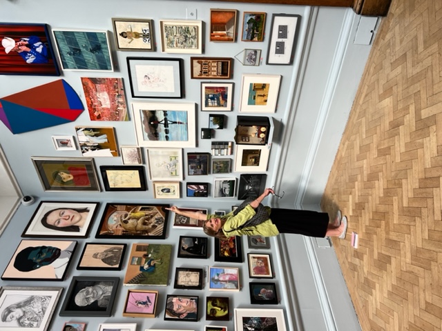 Miranda Carroll looks at her painting, Lady in Red, in this year's Summer Exhibition at the Royal Academy, in London