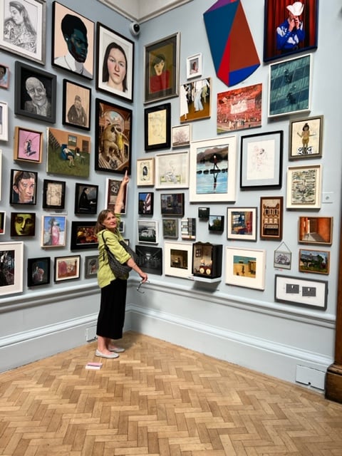 Miranda Carroll looks at her painting, Lady in Red, in this year's Summer Exhibition at the Royal Academy, in London