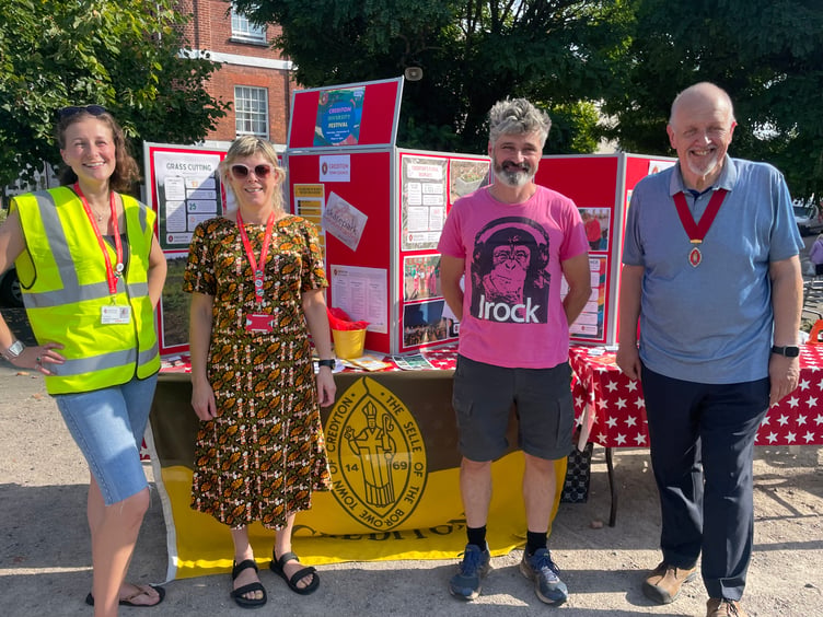 In front of the Crediton Town Council and Crediton Youth Service stalls, from left, Crediton Town Council Projects Officer Jo Davey, Cath Kelly, Crediton Youth Worker, Cllr Giles Fawssett and the Deputy Mayor of Crediton, Cllr Steve Huxtable. AQ 6459