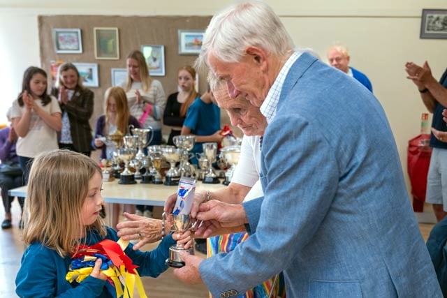 Poppy presented with her cup and rosettes for her handiwork at Walkhampton Flower Show.