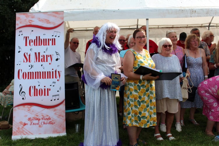 Members of Tedburn Community Choir getting ready to sing with an extra 'member' Phil Dyson, the wandering panto Dame. SR 8899