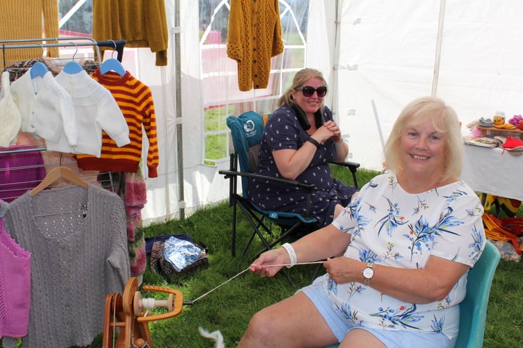 Demonstrating spinning is Marian Durrant with Toni Coles, who does crochet, behind her for Barley Spark Spinners and Knitters. SR 8983