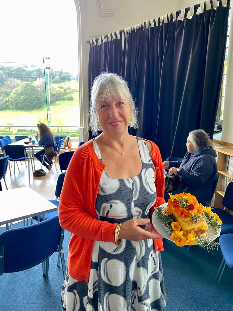 Lily Russell holding her beautiful polenta cake for the Macmillan Coffee Morning at Calstock Arts.