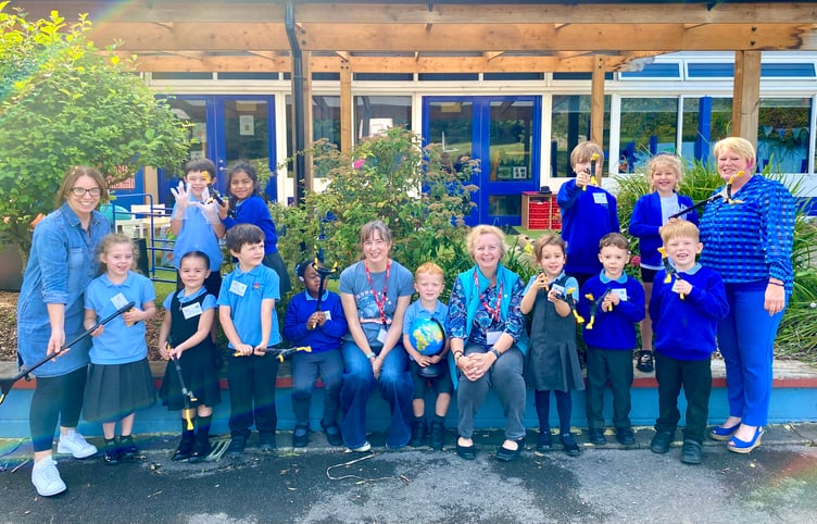 Cllr Ginny Boxall, with Emma Jones from Young ACAN, gives the litter pickers to Wootey Infant School pupils watched by teacher Liz Collins and head Ella Palmer, October 2023.