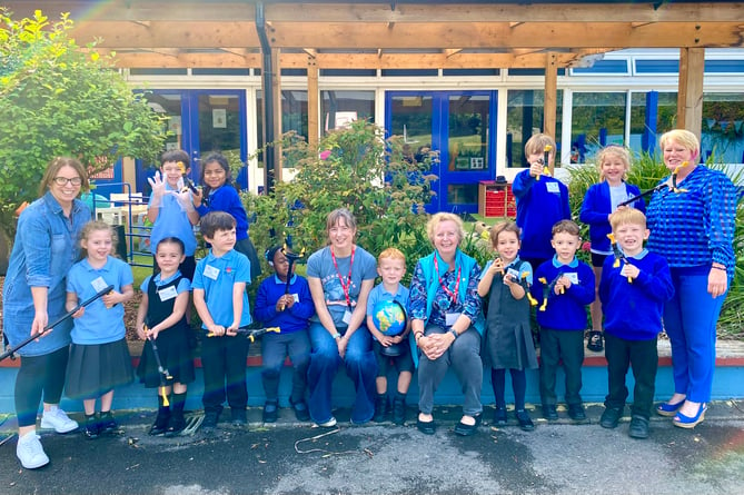 Cllr Ginny Boxall, with Emma Jones from Young ACAN, gives the litter pickers to Wootey Infant School pupils watched by teacher Liz Collins and head Ella Palmer, October 2023.