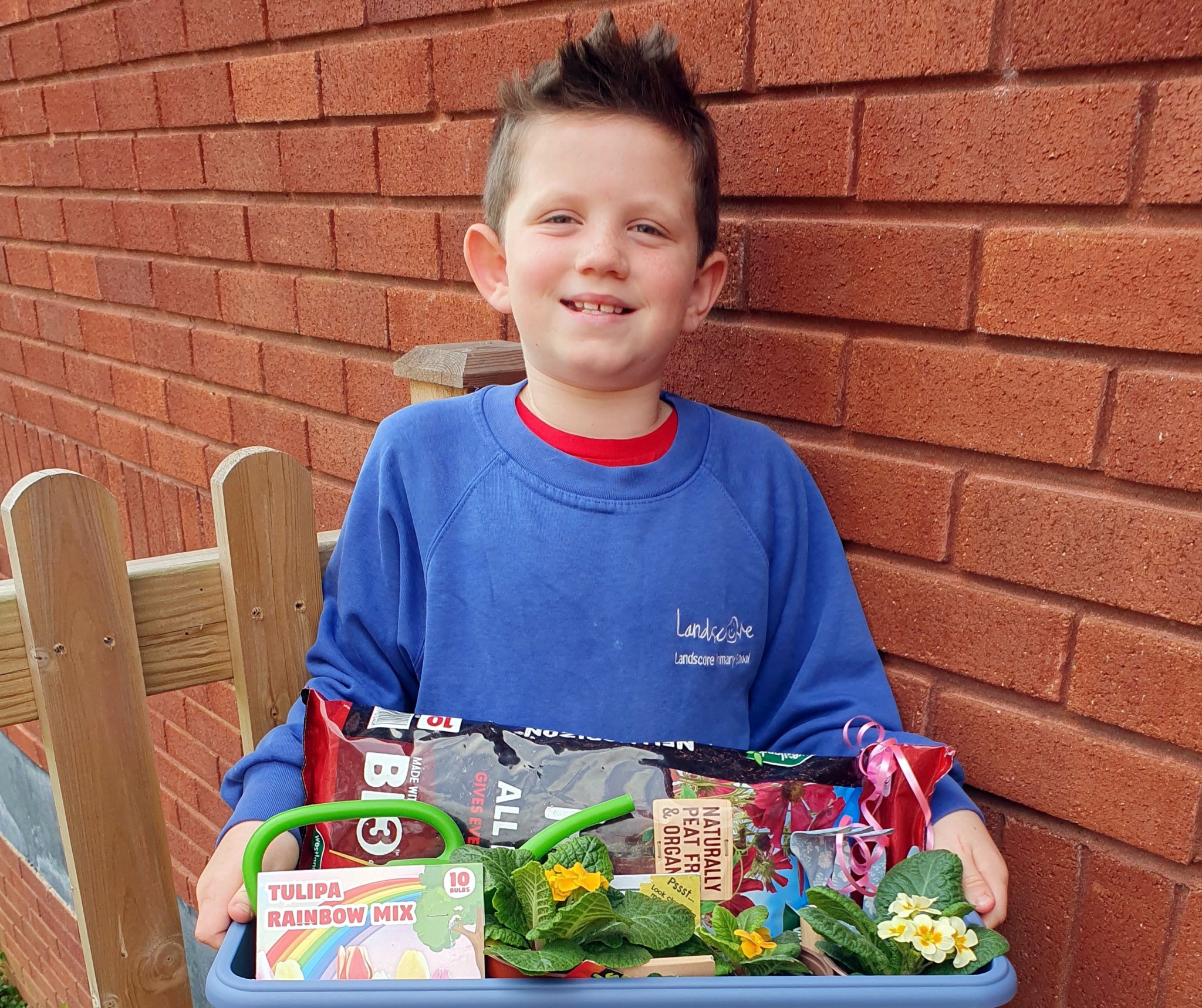 Toby at Crediton Library with his gardening hamper donated by Bernaville Nurseries.