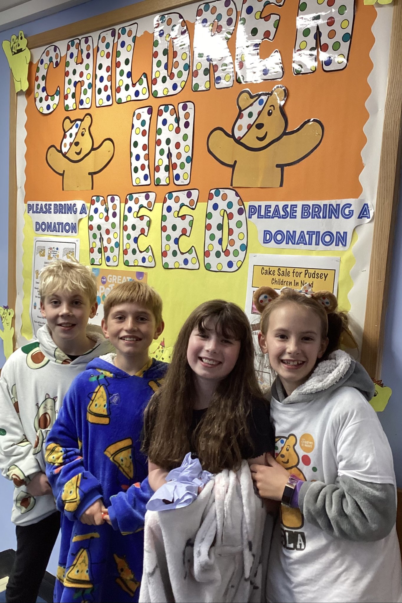 Arbory pupils have their picture taken in front of the dedicated Children In Need board