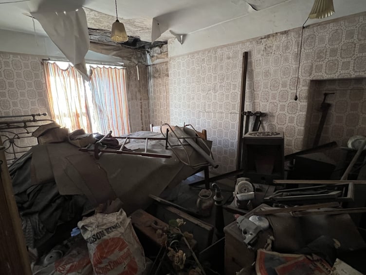 Bedroom cluttered with old furniture in 33 Princes Street. Scan the QR code at the top right-hand corner of this picture to watch a video tour inside the property.