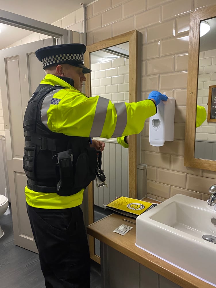 Sgt Dan Lewis using testing wipes on the surfaces within the toilets and cubicles