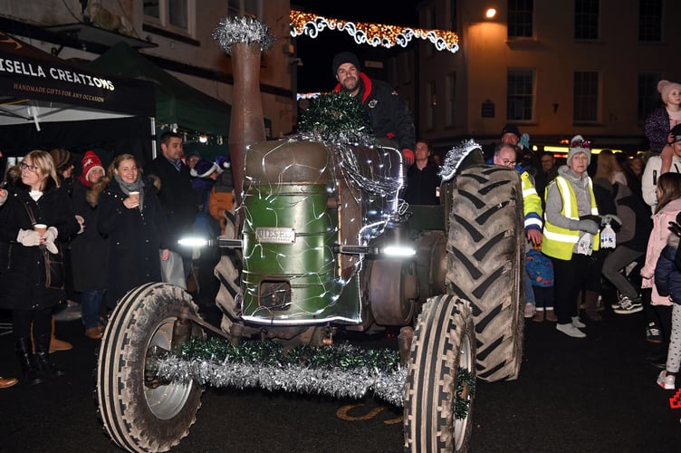 A brightly lit tractor decorated for the parade