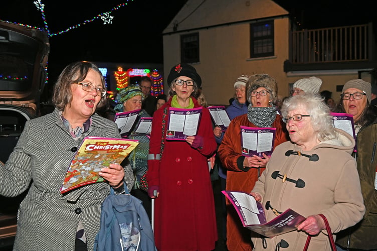 Singing some favourite Carols around the Tree are members of the St Teath Church Choir