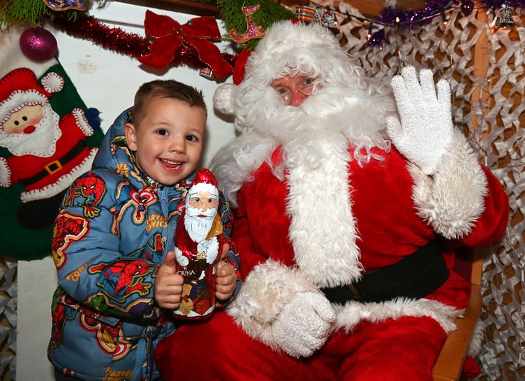 A beaming smile from Max has he meets Father Christmas