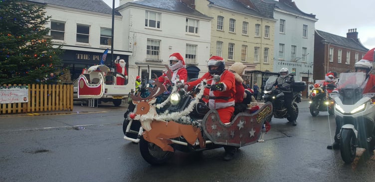 The 'real' Santa can be seen in the background waving off the Santa's On A Bike riders passing through Wellington on Saturday.