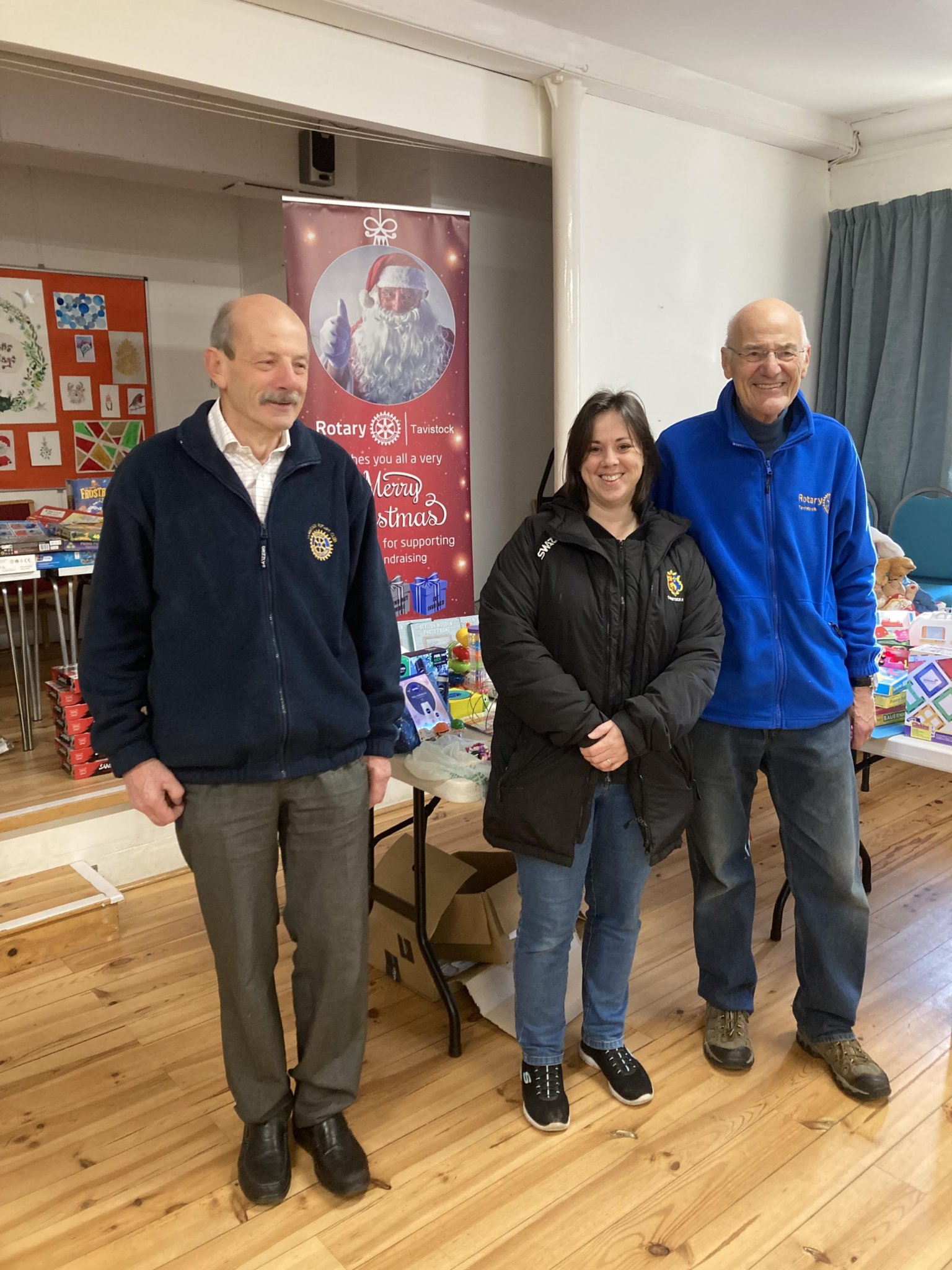Pictured above are rotarians Wally Lake (left) and John Hudson with Isabel Williams at the toy distrribution day last Saturday.