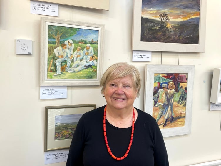 A member of Newton St Cyres Art Group in front of her work in the Boniface Centre. AQ 1657