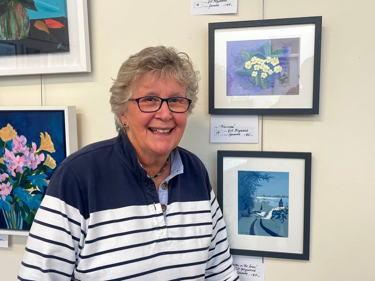 A member of Newton St Cyres Art Group in front of her work in the Boniface Centre. AQ 1659