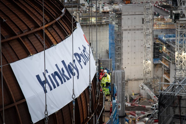 Engineers check Hinkley Point C's first reactor building dome after it was lifted into place by Big Carl.