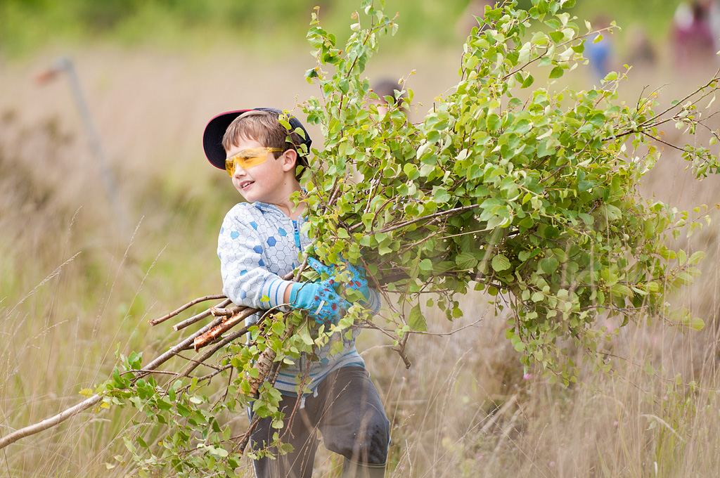 Local school children cut and collect growing tree saplings at Westhay to maintain wetland habitat, Westhay Nature Reserve (Somerset Wildlife Trust), Somerset Levels, Somerset, UK. June 2011. (Model released).