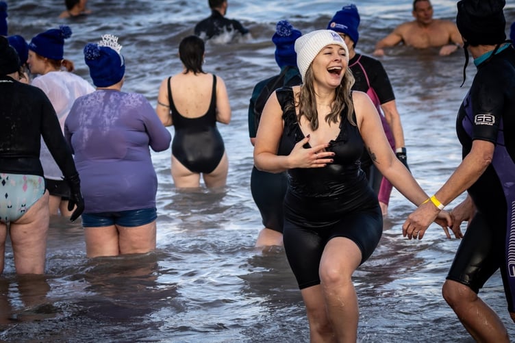 A participant is all smiles as she leaves the water after her dip.