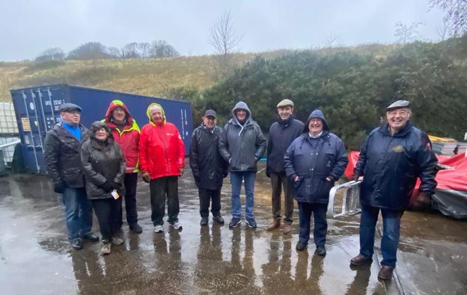 Volunteers from the Rotary Club of Douglas help to load a van full of mobility equipment