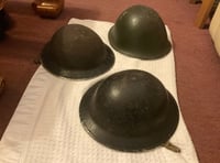<p>These three Second World War-era helmets were discovered at Farnham Station prior to the opening of the Spice Station Indian takeaway in around 1999</p>