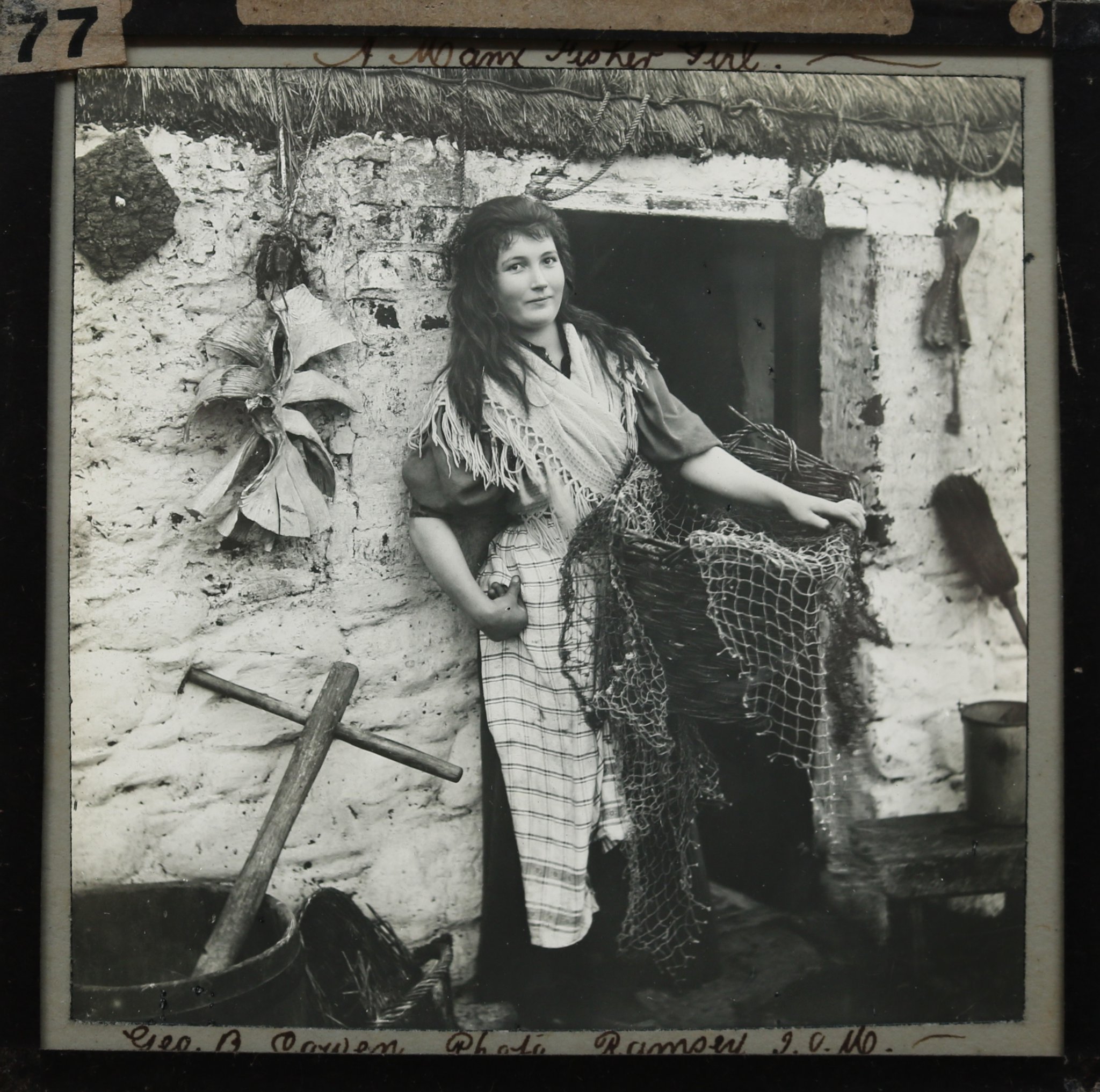 Manx fisher girl Miss Crennell, pictured outside her thatched cottage in an image from late 19th or early 20th century