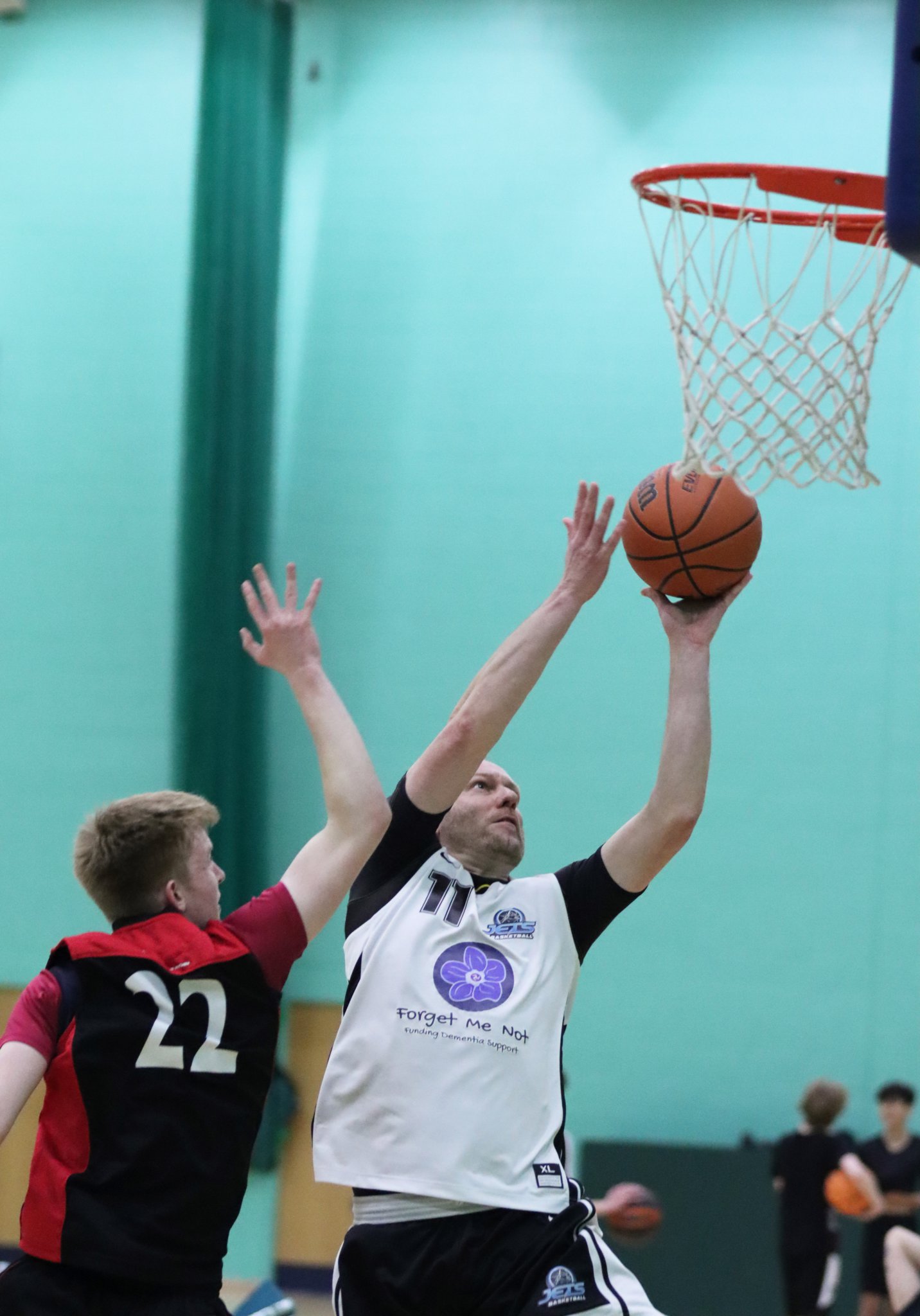 Wayne Mears goes to the hoop for Forget Me Not Jets as Ronan Thompson reaches in to defend