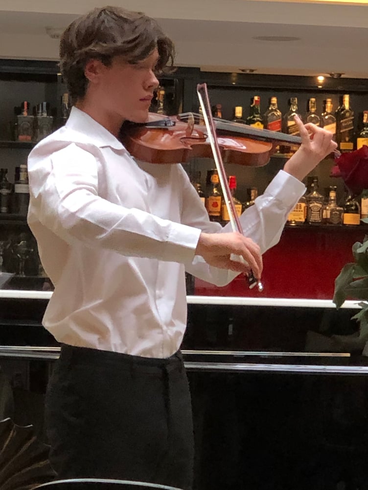 Young violinist Anthony Knight performing in the Aria Hotel, Prague.