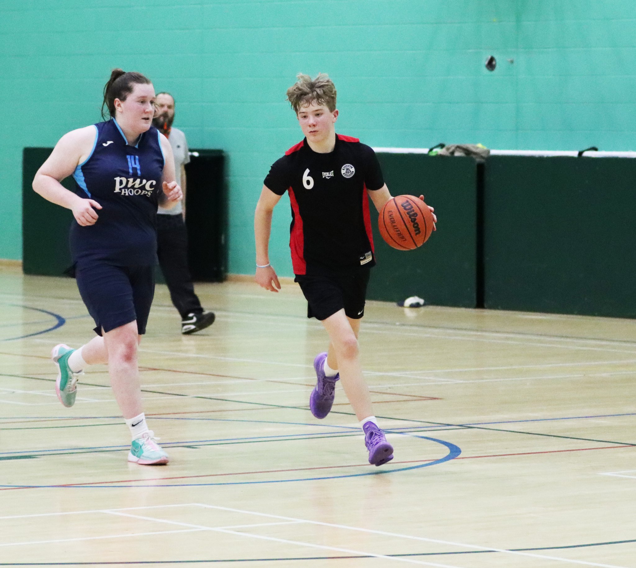 Seb Smith takes the ball down the court for Ravens as Hoops’ Gemma Kirkham hustles back on defence