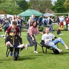 Children enjoying a wheelbarrow race.