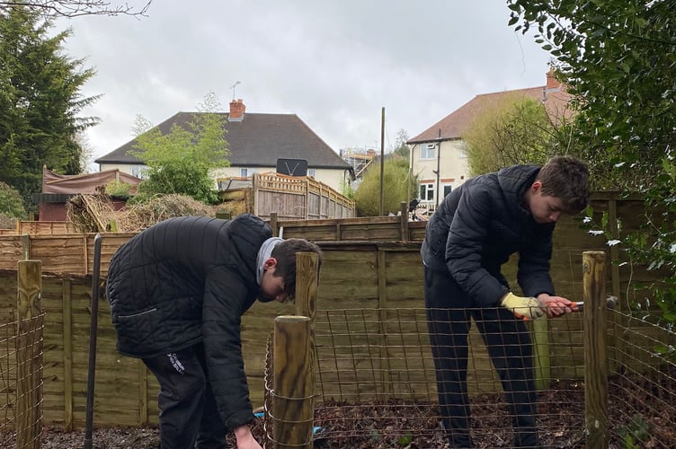 Two young members of the new Wrecclesham Conservation Group help make compost bins in St Peter's churchyard