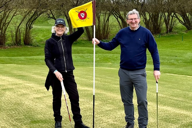 Ann Saunders (left) and Chris Castle (right) celebrate together on the 18th hole at Petersfield Golf Club during its course maintenance week