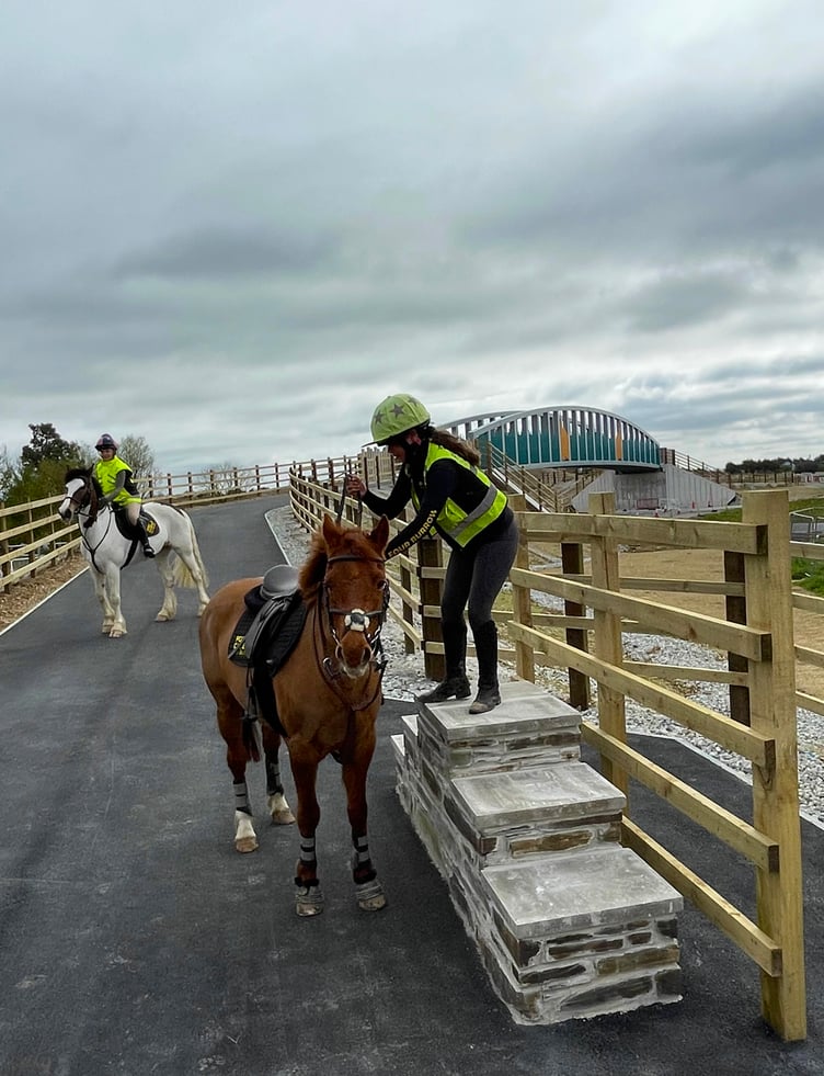 A horse rider uses mounting facilities at the opening of the Blue Bridge at Chiverton Cross