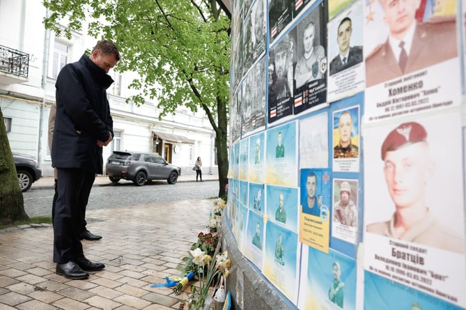 Jeremy Hunt is pictured paying his respects to the fallen at a memorial in Saint Michael's Square, Kyiv.