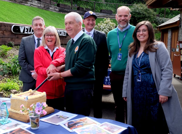 Rob Greenslade helps cut a celebratory cake made by college catering students. PHOTO: Terry Walker.