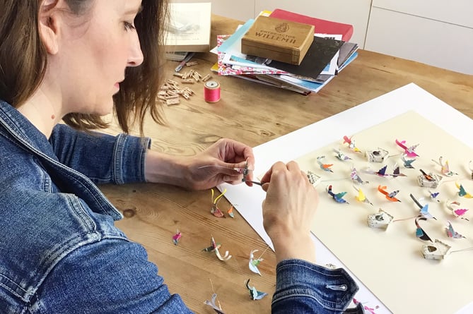 Lucy making paper birds for an artwork 
