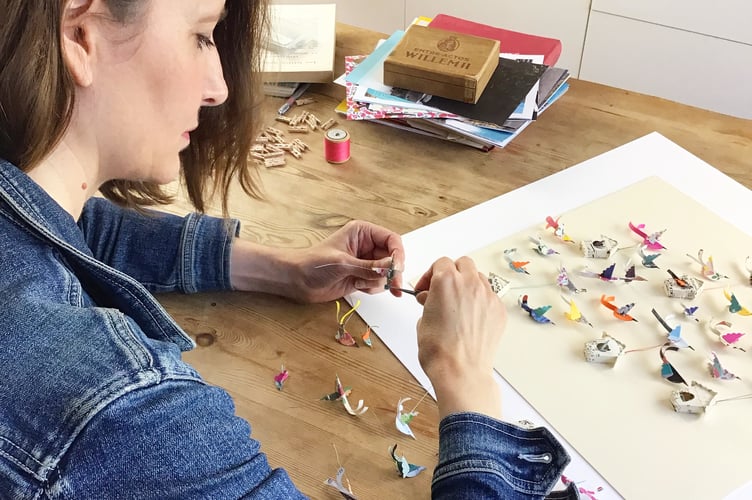 Lucy making paper birds for an artwork 