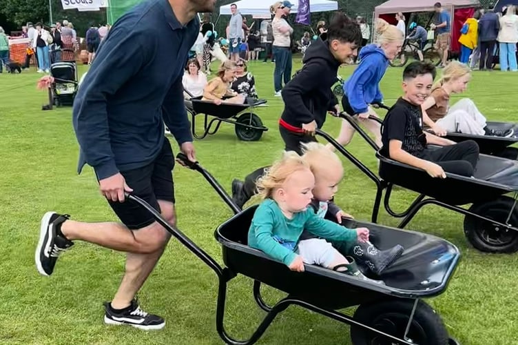 Families and individuals race against each other in the wheelbarrow race
