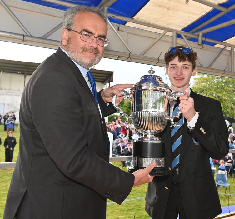 Festival president Geraint Richards presents the Royal Trophy to championship section winners Camborne. Receiving the trophy is trombone player Cory Williams. Picture: Adrian Jasper