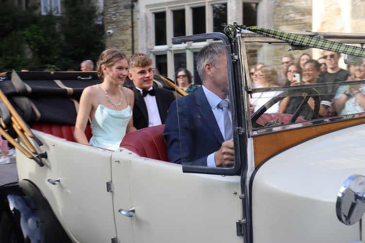 An open-top car brings a pair of students to the prom.