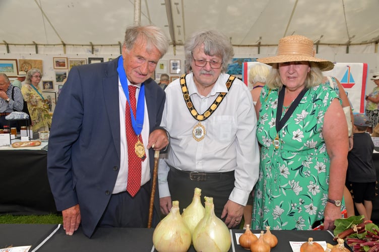 Somerset Council chairman Cllr Mike Best (centre) with his wife Elizabeth and former Wellington MP David Nicholson inspecting produce entries in Taunton Flower Show. PHOTO: Alain Lockyer.