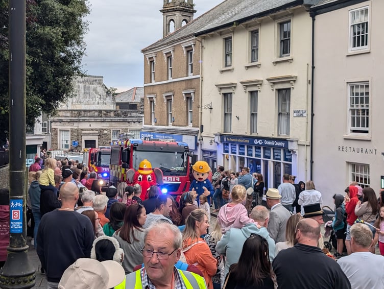 Crowds eagerly welcome the arrival of the carnival, led by the fire service