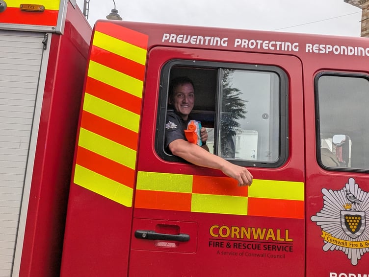 Sam Goodswen of the Cornwall Fire and Rescue service dampens the heat of the day by dousing the crowd with a water pistol