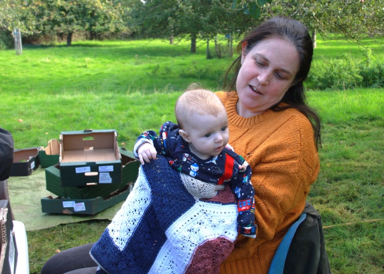 Tanya Watson with three-month-old Molly learning about apples at Carhampton Apple Day. PHOTO: George Ody.