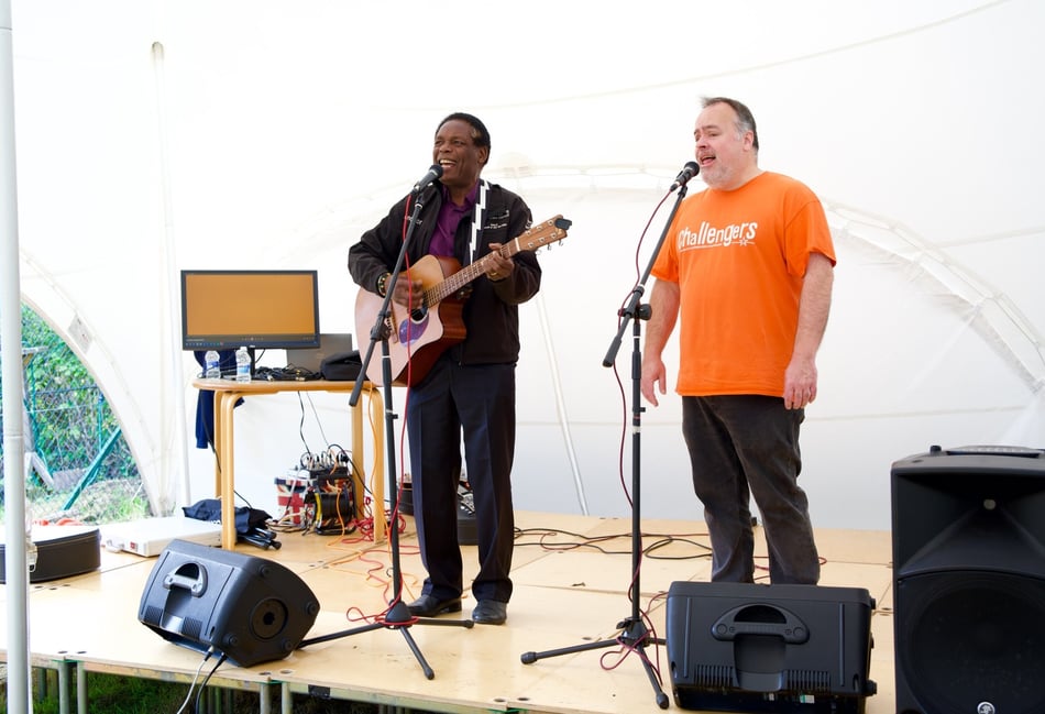 <p>Farnham mayor, Cllr, Brodie Mauluka on stage at Orange Aid.</p>