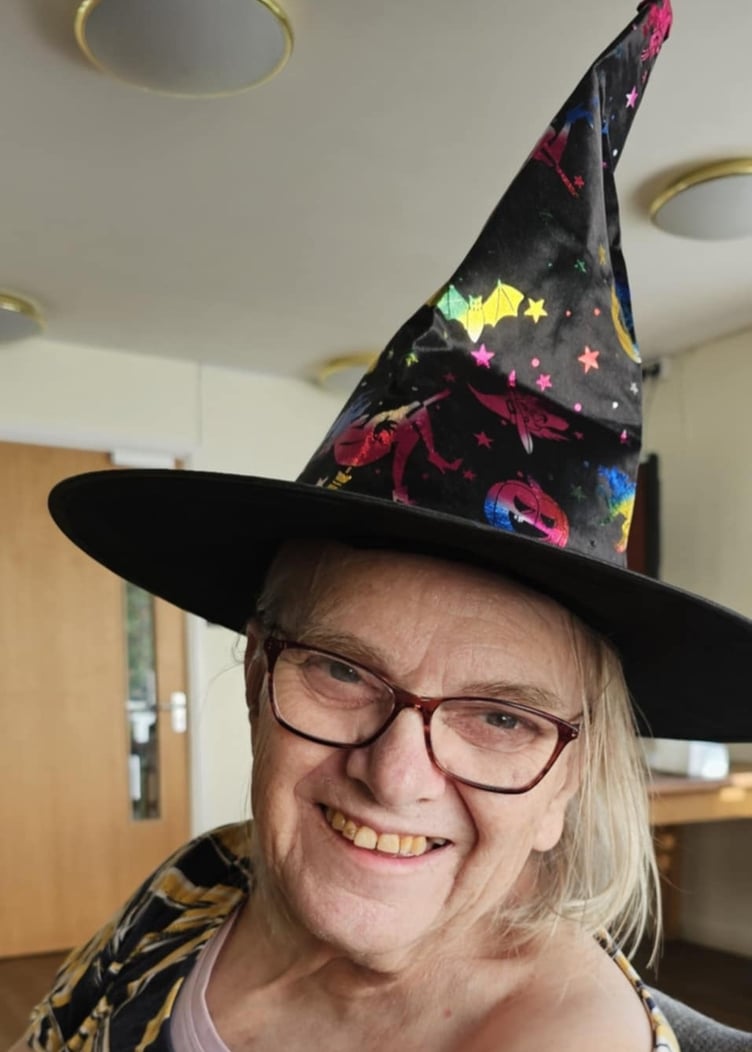 Linda Shute wearing her Halloween witch's hat in Camelot House and Lodge.
