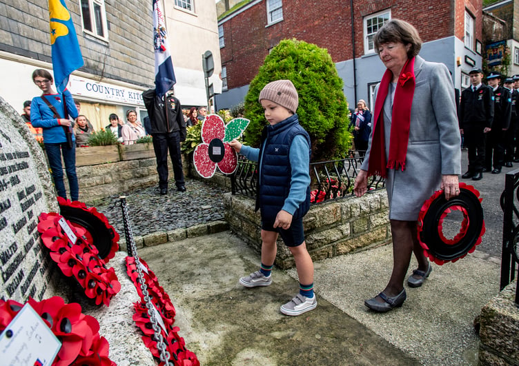 A youngster places a tribute at the war memorial in Mevagissey. Picture: Paul Williams