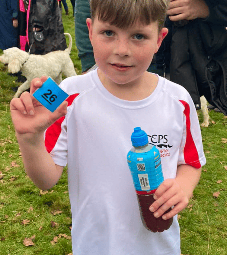 Lukas Capewell of Callington Primary School gets a well-deserved drink after completing the Lanhydrock race