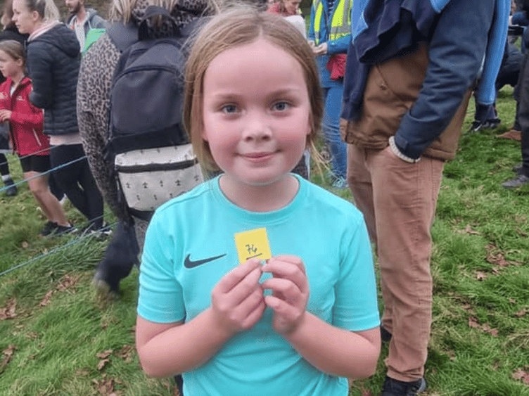 Ava Campbell from Carbeile Primary School smiles after completing the Lanhydrock Cross Country course